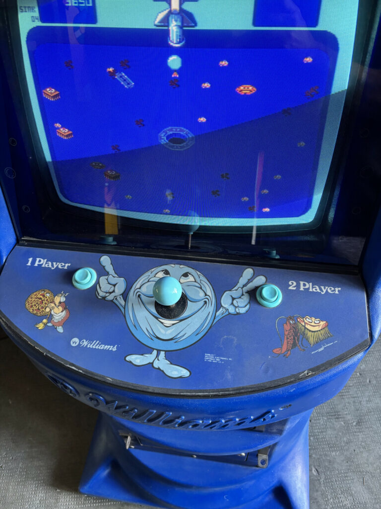 Dettaglio della plancia di comando originale di Bubbles, con il caratteristico joystick a 8 vie azzurro, le grafiche d'epoca e i tasti 1/2 Player