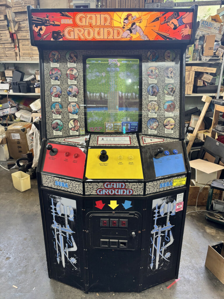 Vista frontale completa del videogioco arcade Gain Ground, con il raro schermo CRT Wells Gardner a 24 kHz, plancia comandi e gettoniera originale.