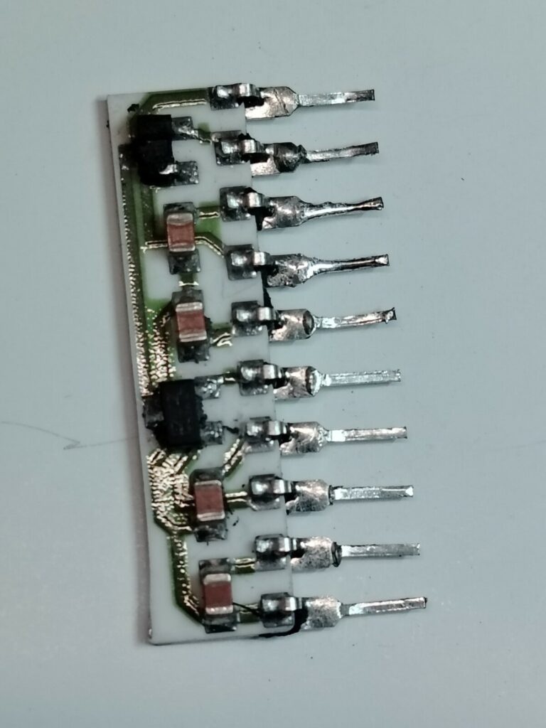 Fotografia macro di un componente elettronico custom TRJ-001 estratto da una scheda arcade. L'involucro di plastica esterna è stato rimosso chimicamente nel laboratorio Arcade Story per esporre e riparare i contatti interni bruciati, salvando la PCB originale