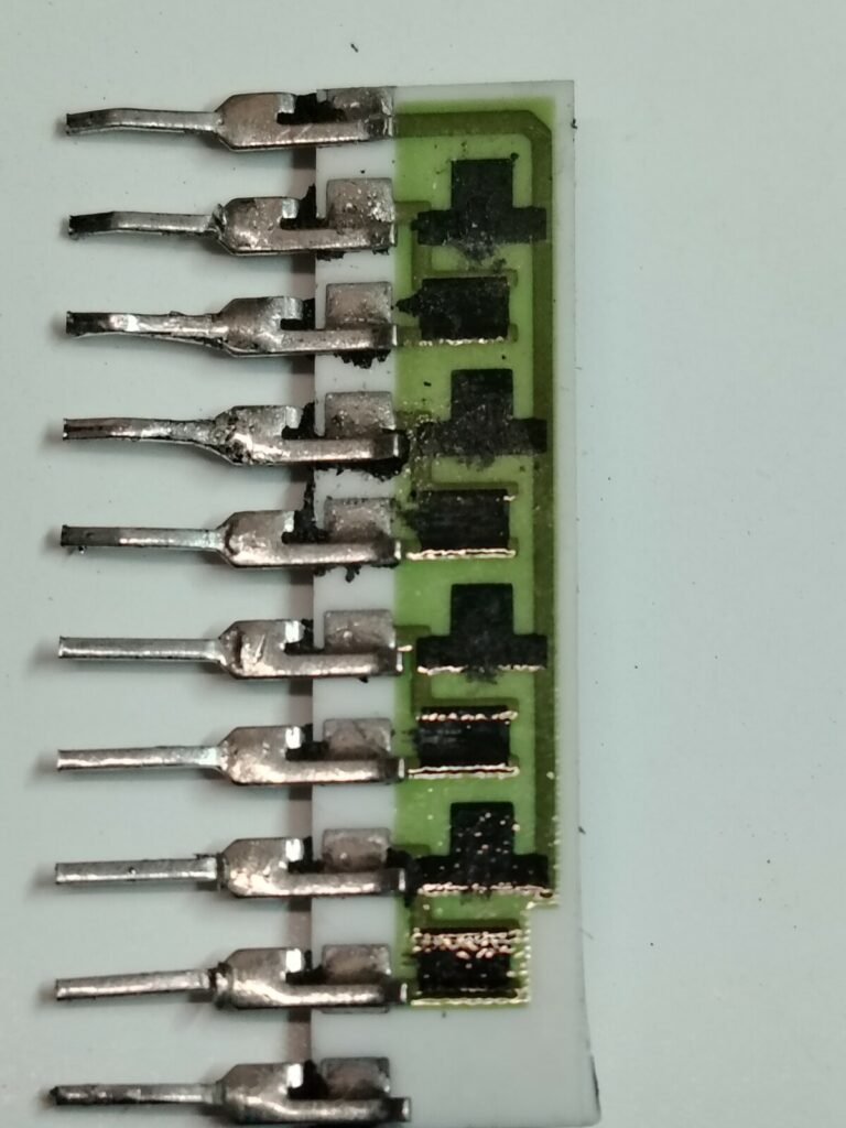 Fotografia macro di un componente elettronico custom TRJ-001 estratto da una scheda arcade. L'involucro di plastica esterna è stato rimosso chimicamente nel laboratorio Arcade Story per esporre e riparare i contatti interni bruciati, salvando la PCB originale