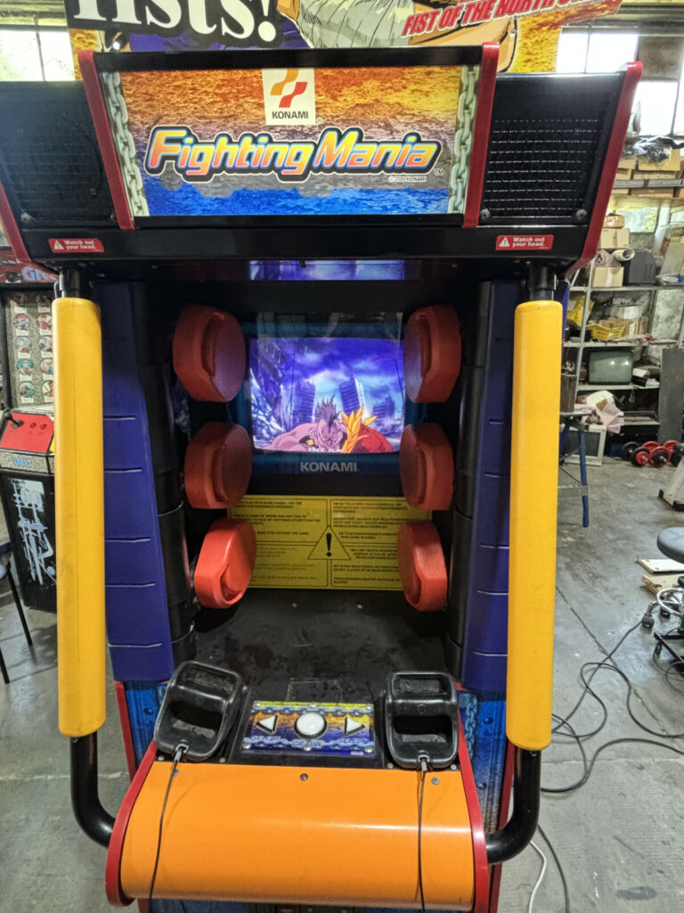 Inquadratura ravvicinata del monitor e della plancia di Fighting Mania, in evidenza i sei iconici bersagli meccanici da colpire a suon di pugni.